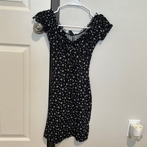 Black dress with white flowers. Sleeves can be on shoulder or slid down shoulder